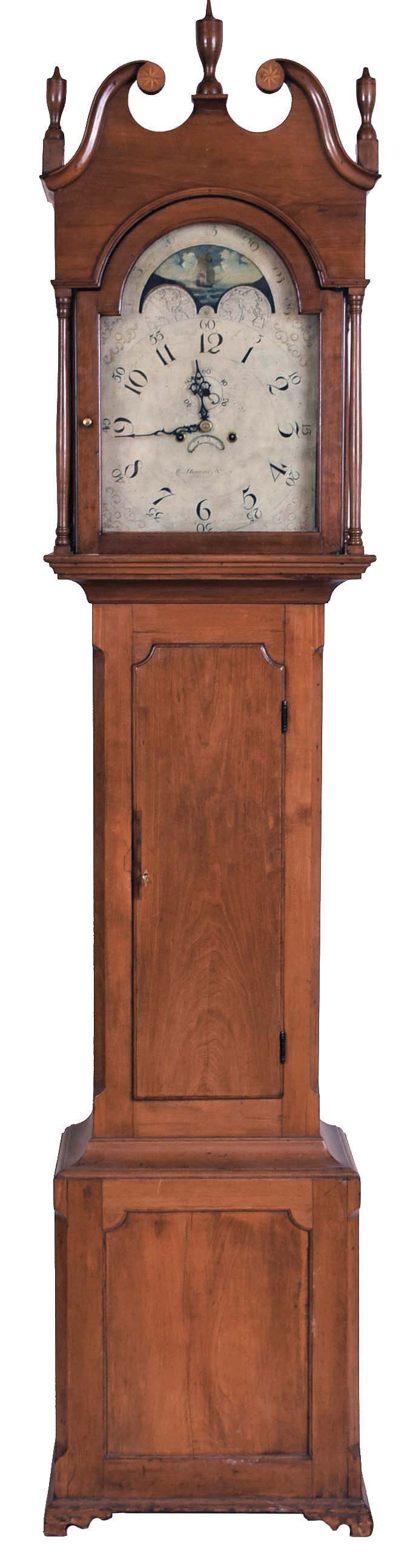 William Herwick (Sr.) , Greensburg, Penn., "No. 6" tall case clock, 8 day, time and strike, weight driven movement in a cherry case with broken arch top, three turned wooden finials, star inlaid rosettes and four full columns flanking hood, bracket base with recessed panel. The painted metal dial with maker's signature has date calendar and moon phase. The dial's false plate is signed "PATTON &amp; JONES PHILA". — Antique Clocks Price Guide