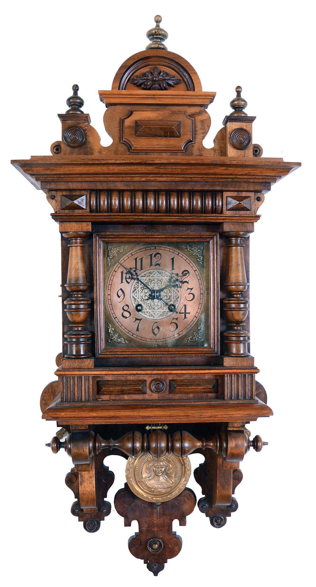 Lenzkirch Clock Co., Germany, "Freischwinger" wall clock, 8 days, time and bim bam 1/4 strike, spring driven movement in an Alt Deutsch walnut case with pressed brass pendulum featuring female bust. The dial is brass with silvered engraved center and applied cast brass spandrels. — Antique Clocks Price Guide