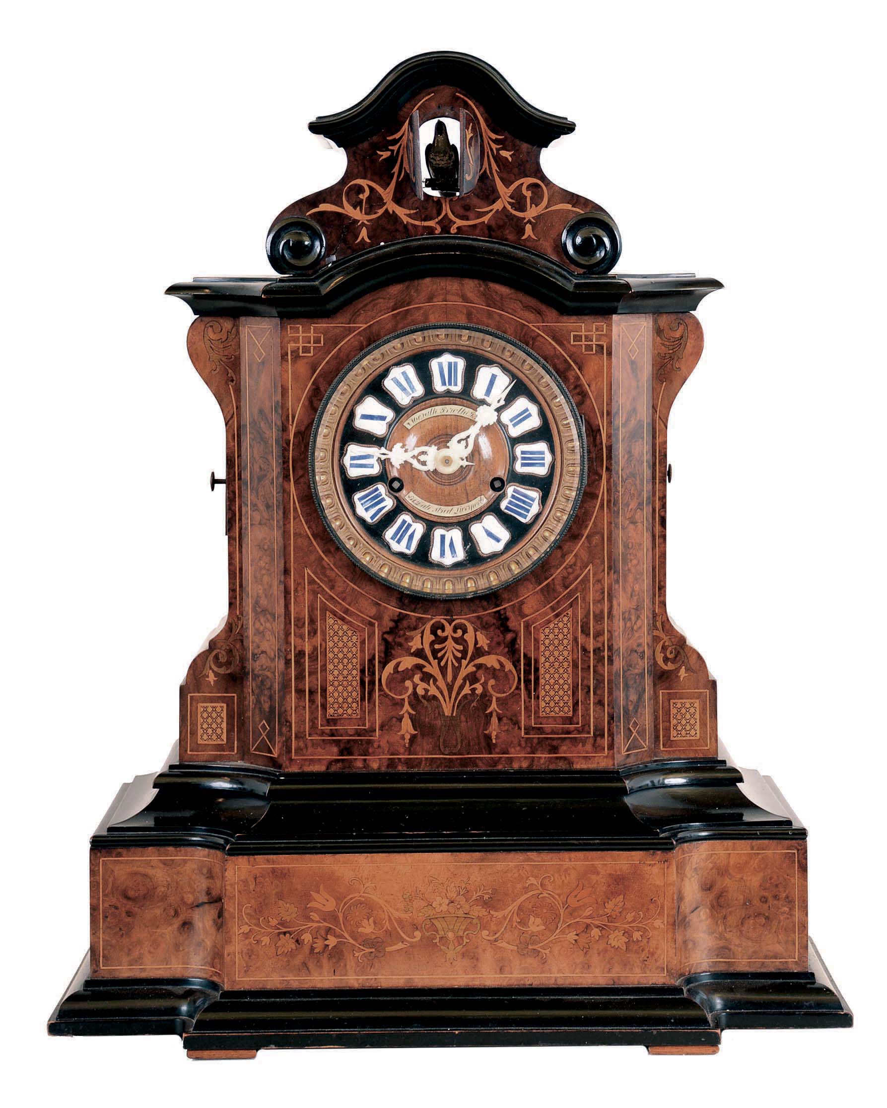 Johann Baptiste Beha, Germany, Black Forest shelf cuckoo. 8 day wood plate spring-driven movement with 6 tune Swiss music box in base, actuated by the clock movement. Case of burled walnut, finely inlaid with satinwood in a scrolling floral design. The wooden dial carries 12 porcelain cartouche with royal blue Roman Numerals. This model "No. 593" is illustrated in Justin Miller's book, Appendix A which is the Beha catalogue reprinted. — Antique Clocks Price Guide