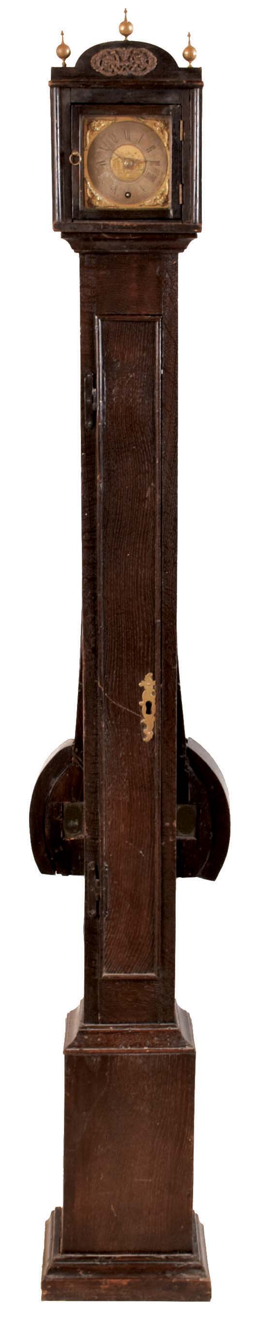 Jno. Walker, Hinley Mill, tall clock, extremely narrow oak case with "wings" to accomodate the pendulum amplitude, door with brass escutcheon and foliated H hinges, brass dial with Roman numeral chapter ring and gilt spandrels, blued steel hands, 8 day brass timepiece with very fancy turned pillars and recoil escapement, with pendulum and weight, dial signed, 18th century — Antique Clocks Price Guide