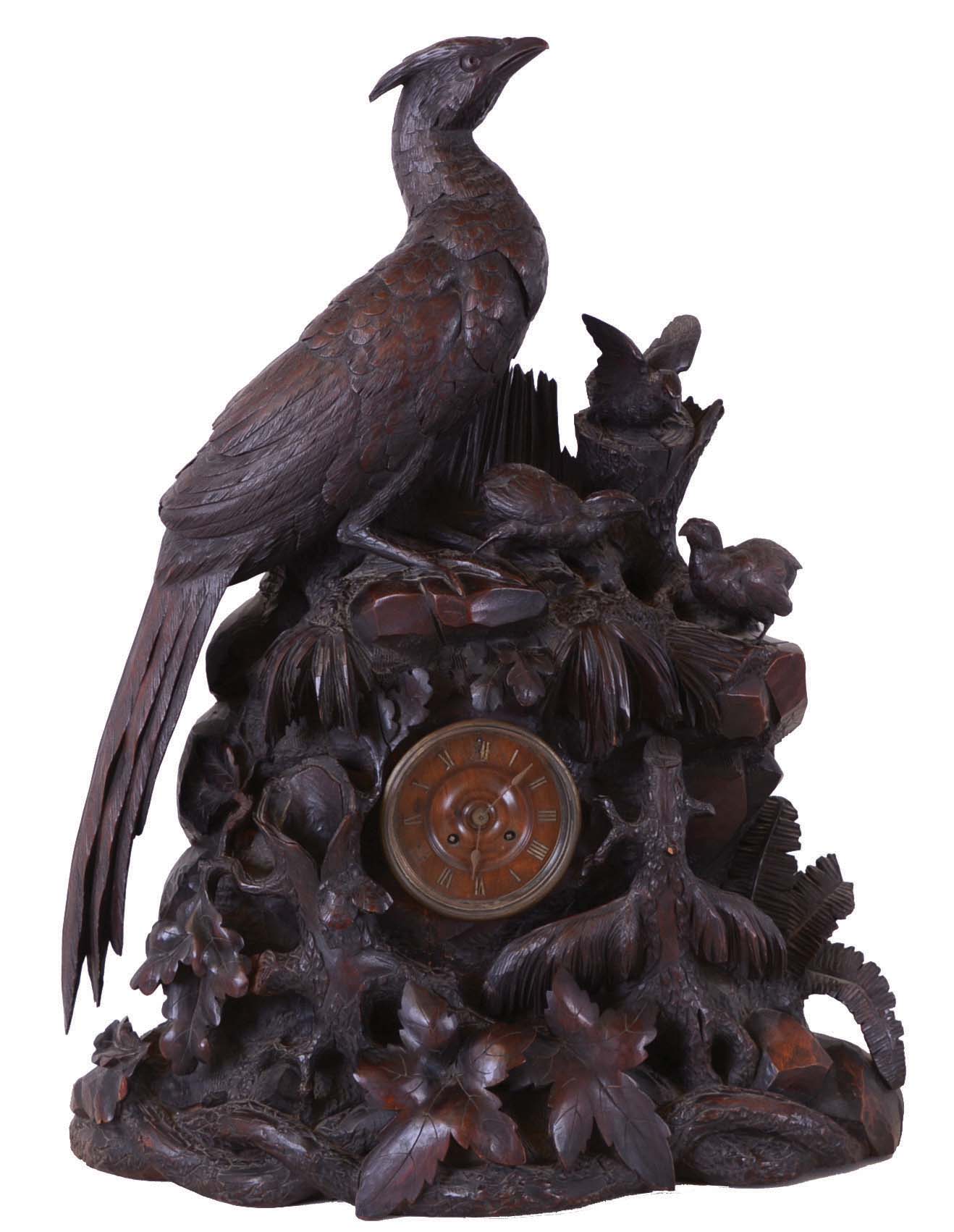 Black forest mantel clock, the monumental carved case featuring a female pheasant watching over three chicks exploring the forest floor, realistically rendered rocks, ferns, leaves, fungi and timber, with carvers stamp, "eb" at lower left, back, turned wooden dial with applied brass Roman numerals, 8 day time and strike pendule a Paris movement — Antique Clocks Price Guide