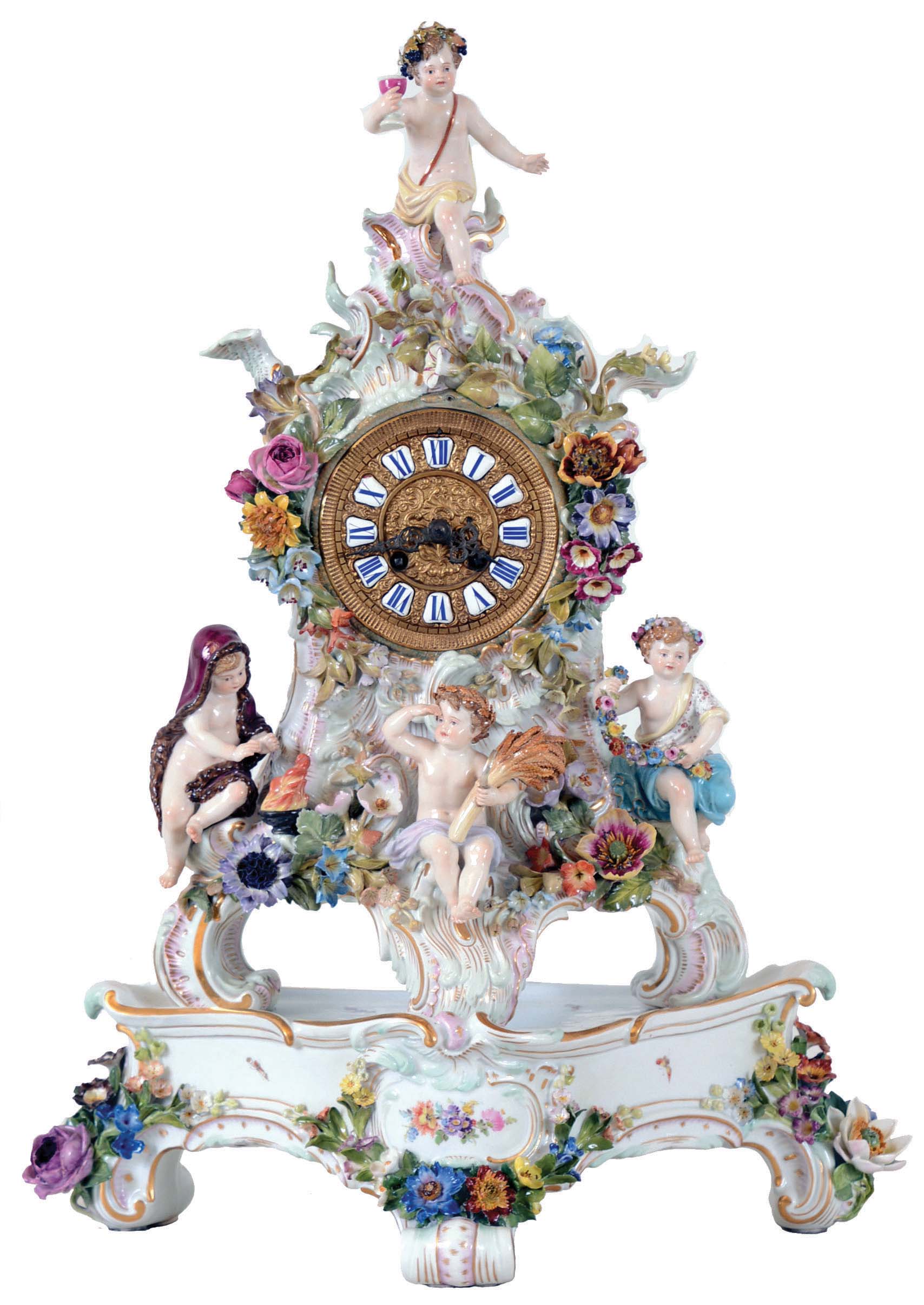 Lenzkirch, Germany, porcelain mantel clock on porcelain stand by Meissen, 8 days, time and strike, spring driven movement in a highly elaborate and delicate polychrome porcelain Meissen case decorated with several putti, floral and foliate elements resting on matching Meissen porcelain stand. The fancy cast brass dial is set with twelve blue Roman numeral cartouches, serial #1110301 — Antique Clocks Price Guide