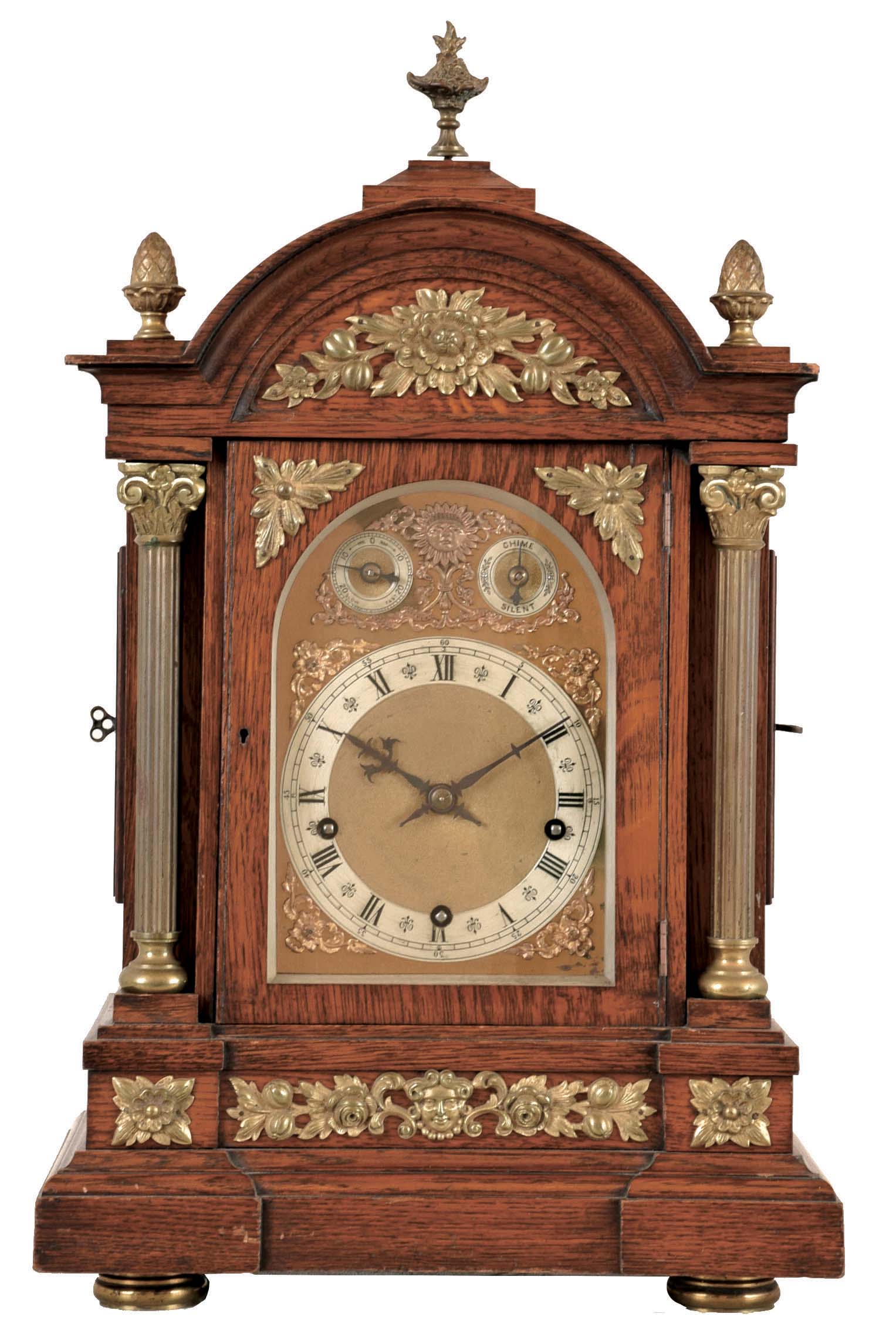 Winterhalder &amp; Hofmeier, Germany, Westminster chime bracket clock, oak case with molded base and arched, molded top, with fluted columns, and applied foliate ornament, the composite dial with gilt spandrels, silvered chapter ring, chime and rate control dials, blued steel hands, 8 day, 3 train quarter chiming movement, sounding on 4 gongs at the quarters, and striking the hours on a larger gong, back plate signed — Antique Clocks Price Guide