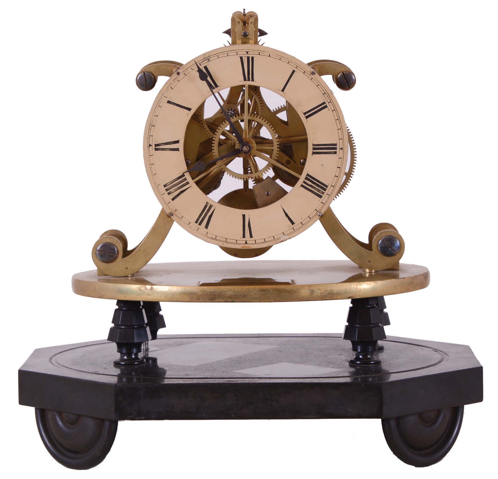England, after Strutt &amp; Wigston, skeleton clock with epicyclic gearing, 8 day timepiece movement with fusee, well executed five spoke gearing, and nicely finished pierced brass plates, the epicyclic gearing visible between the front plate and the Roman numeral painted dial, blued steel spade hands, the movement mounted to an oval brass plate, the plate with plaque engraved "Wm. Strutt Esqr. Invt", the plate supported on four tapered columns, all on an oval, black slate base with half round turned feet — Antique Clocks Price Guide