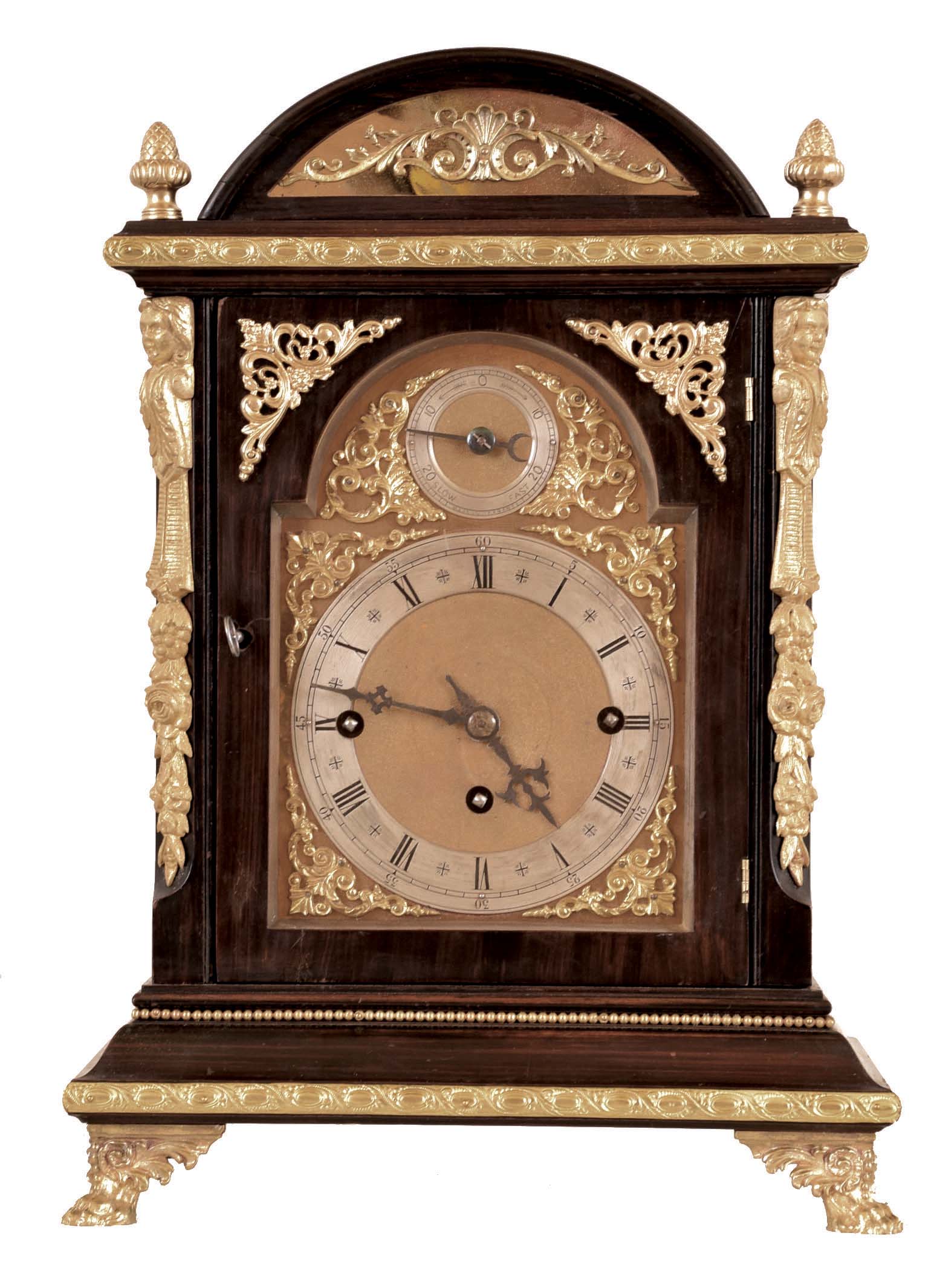 Winterhalder &amp; Hofmeier, Germany, Westminster chime bracket clock, rosewood grained hardwood case with molded base and arched, molded top, and applied gilt ornament, the composite dial with gilt spandrels, silvered chapter ring, and rating control dial in the arch, blued steel hands, 8 day, 3 train quarter chiming fusee movement, sounding on 4 gongs at the quarters, and striking the hours on a larger gong, back plate signed — Antique Clocks Price Guide