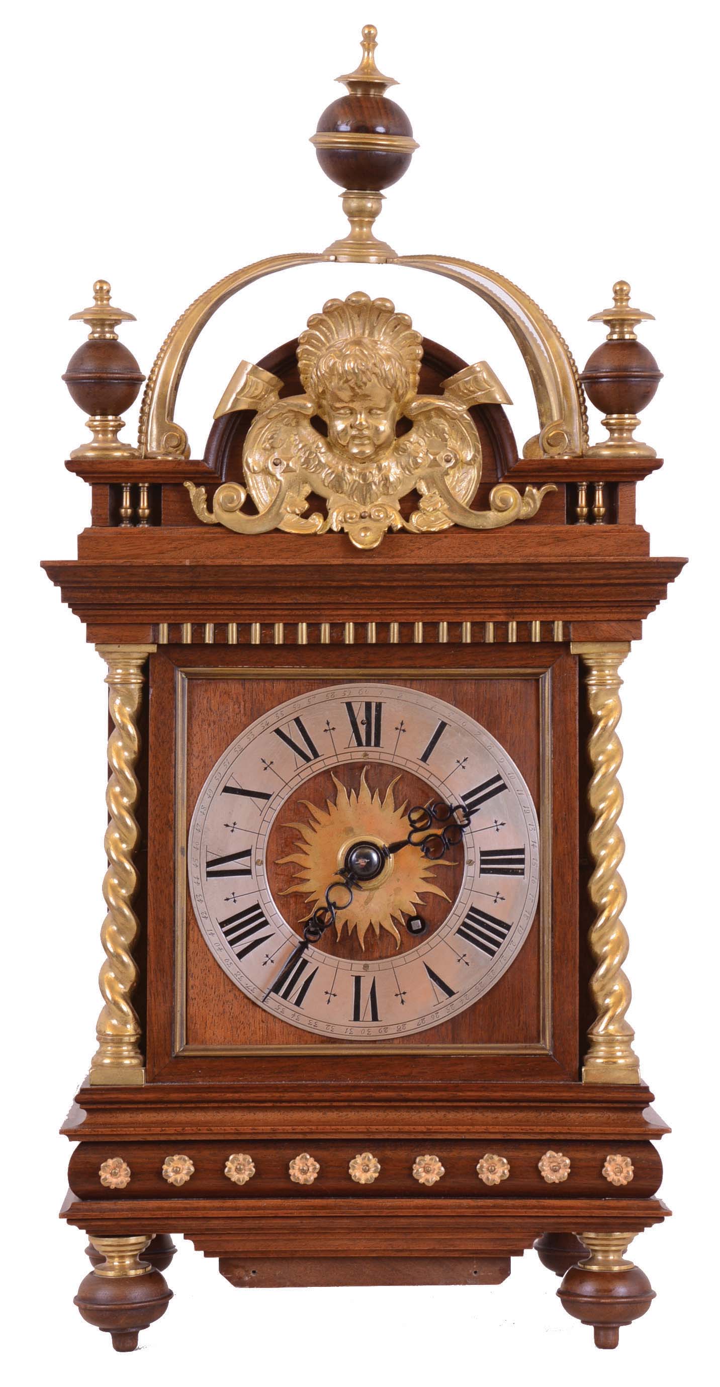 Germany, bracket clock, 8 days, time and strike, spring driven movement in a walnut case with brass twist columns and other brass trim and appliques and surmounted by arched brass structure with silvered chapter ring. — Antique Clocks Price Guide