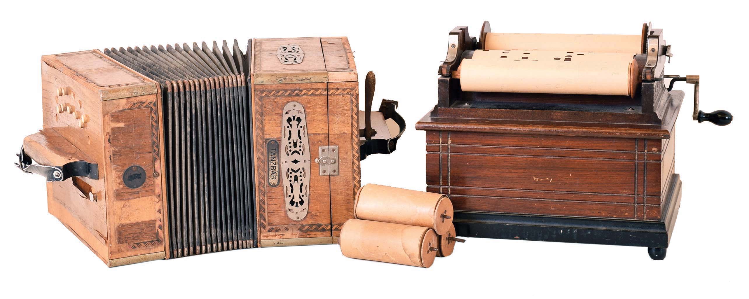 Two musical instruments. (1) An American-made roller organ with one 8" long paper roll. (2) A "Tansbar" player concertina made by A. Zuleger of Leipzig Germany with six 4.5 inch paper rolls. — Antique Clocks Price Guide