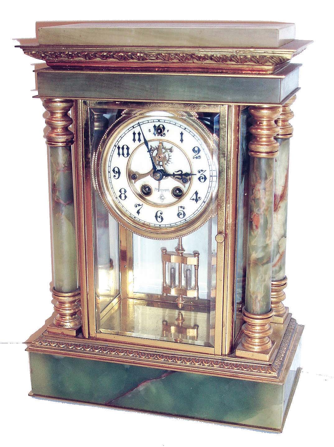 William L. Gilbert Clock Co., Winsted, Conn., Magdalene variant crystal regulator, green onyx case with gilt brass mounts, beveled glasses, Arabic numeral white enamel dial with sunk center, exposed escapement and beat adjustment, blued steel hands, 8 days, time and strike, movement with round plates, faux mercury pendulum. — Antique Clocks Price Guide