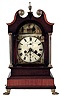Bracket clock, mahogany and mahogany veneer case, the stepped base with ebony inlays, and resting on cast paw feet, supporting a tall clock style bonnet with brass columns, ebony plinth block and boxwood broken arch and top molding, painted sheet iron dial with Roman numeral chapter ring, faux date display, and with paintings of ruins in the arch and spandrels, steel hands, 8 day time and strike fusee movement, brass pendulum, 19th century