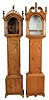 Tall Clock Cases Only- 2 (Two) professionally bench made in tiger maple: (1) broken arch top, flame finials, tombstone door on cutout bracket feet; (2) Roxbury style case with fluted corner columns having brass capitals and bases on ogee bracket feet