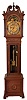 J.J. Elliot, London, England, tall clock, 8 days, time, strike and chiming on gongs, three brass weight driven movement signed Elliot in an oak case with broken arch on hood flanked by full columns, carved rosettes, glazed trunk door, reeded quarter columns and ogee feet. The brass dial has silvered chapter ring and moon phase.