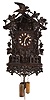 Black Forest hanging Flute Clock, the large carved case with carved vines, leaves and grapes, the top with similar ornament, and also a bird, the base with rustic railing, and with more trailing vines below, wooden dial with applied Roman numerals and carved bone hands, above the doors concealing the musicians, 30 hour, two train wood plate movement with brass wheels, the bellows mounted above, and with windchest and pipes at lower right, carved grape and leaf pendulum, brass weights