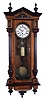 Germany, unsigned Vienna regulator, 8 days, time only, weight driven movement in a two tone carved walnut case with carved appliques and two part white enamel dial.
