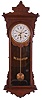 E. N. Welch Mfg. Co., Forestville, Conn., "Sembrich" wall hanging clock with a spring driven 8 day timepiece movement with a simple calendar mechanism in a black walnut case.