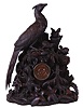 Black forest mantel clock, the monumental carved case featuring a female pheasant watching over three chicks exploring the forest floor, realistically rendered rocks, ferns, leaves, fungi and timber, with carvers stamp, "eb" at lower left, back, turned wooden dial with applied brass Roman numerals, 8 day time and strike pendule a Paris movement