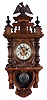 Junghans, Wurttemberg, Germany, "Freischwinger" type wall clock, 8 days, time and strike, spring driven movement in an Alt Deustch walnut case with glazed window over pressed brass pendulum and surmounted by eagle. The dial is a cream enamel two part with brass pressed center.