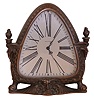 Waltham Clock Co., Waltham, Mass., cast bronze timepiece, the patinated case with satyr mask at center of base, sides with caryatids bearing torches on their heads, and with paw feet, Roman numeral, silvered triangular dial, 8 day time only movement