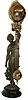 Ansonia Clock Co., Ansonia, New York, "Huntress" figural swinger, the patinated spelter figure of a young woman carrying game birds and holding the clock aloft in her right hand, mounted to an ebonized cast iron base, 8 day time only movement mounted inside a brass sphere with cast ribbon ornament and applied Arabic numerals, Louis XV style hands, the lower section in gridiron style with smaller sphere at the bottom, c1900
