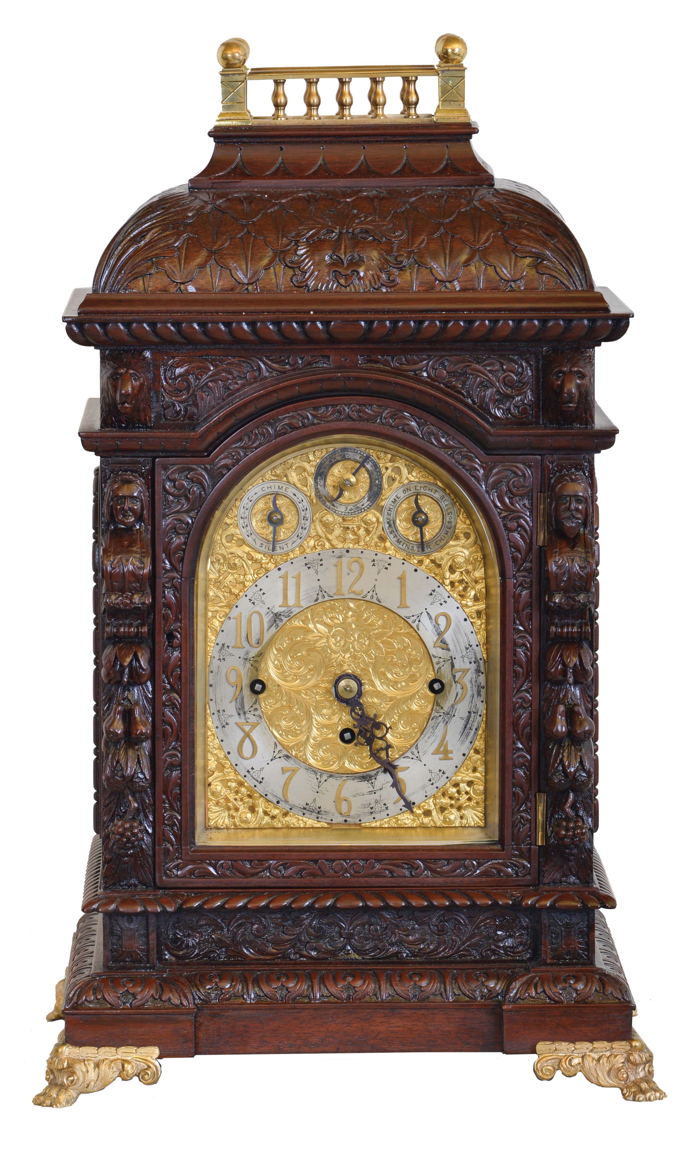 England, unsigned large, three train chiming bracket clock, mahogany case richly ornamented with low and high relief carving, with brass balustrade at top, and resting on gilt paw feet, door with beveled glass, composite dial with Arabic numeral chapter ring, dial plate with engraved center, gilt spandrels, and with rating and chime selection dials in the arch, blued steel hands, substantial 8 day, three train fusee movement chiming on four gongs or eight bells at the quarters, the fourth quarter also with hour striking on a large gong — Antique Clocks Price Guide