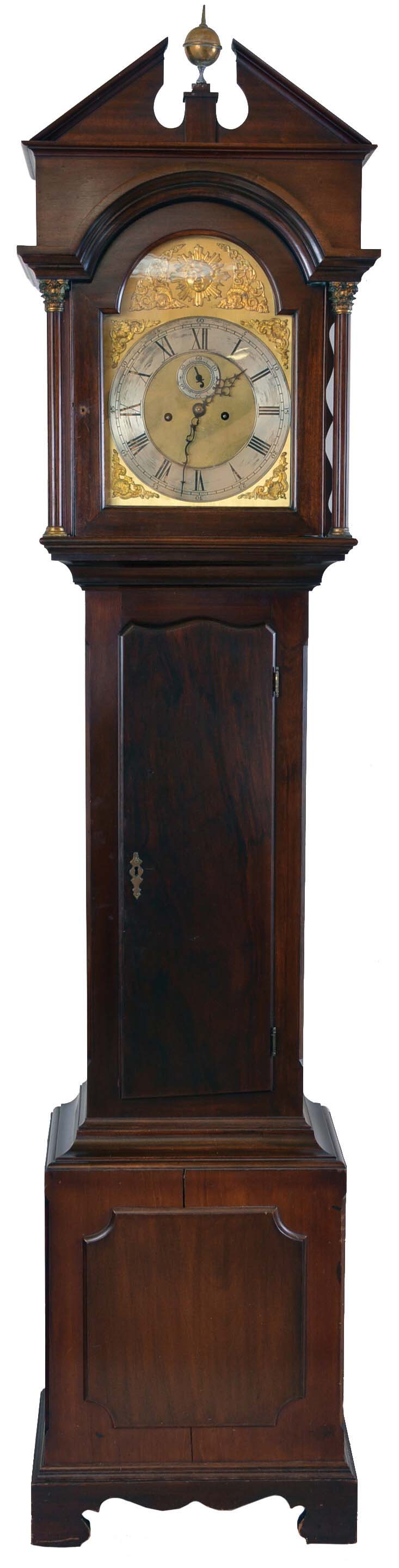 England, tall clock, 8 day, time and strike on gongs, weight driven movement in a mahogany case with pediment top and center brass finial, full columns flanking hood door with brass Corinthian capitals on applied bracket base with brass dial, silvered chapter ring, silvered second's bit and cast brass spandrels and boss. — Antique Clocks Price Guide