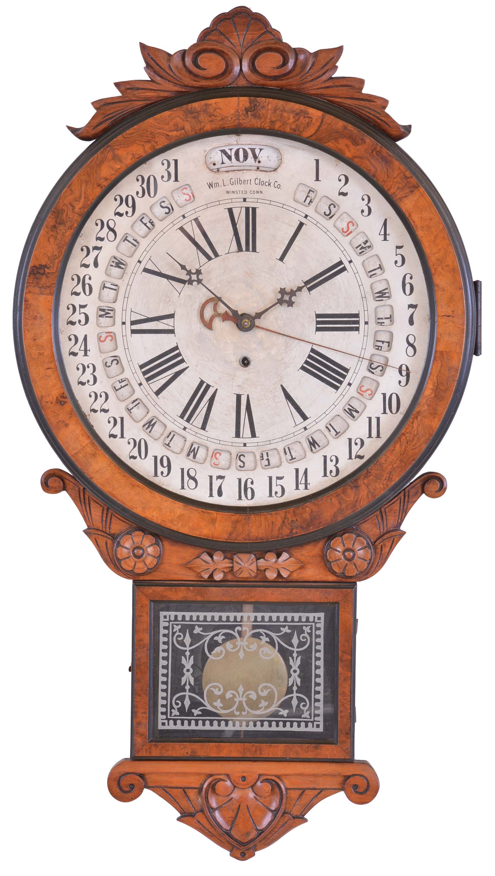 William L. Gilbert Clock Co., Winsted, Conn., "Office Drop Calendar", 8 day, spring brass movement calendar wall timepiece. The dial was made of three layers of thin paper covered metal disks. Gilbert made these with the calendar date ring to be advanced with a pin instead of the winding key in order to circumvent Gausha Maranville's patent. — Antique Clocks Price Guide