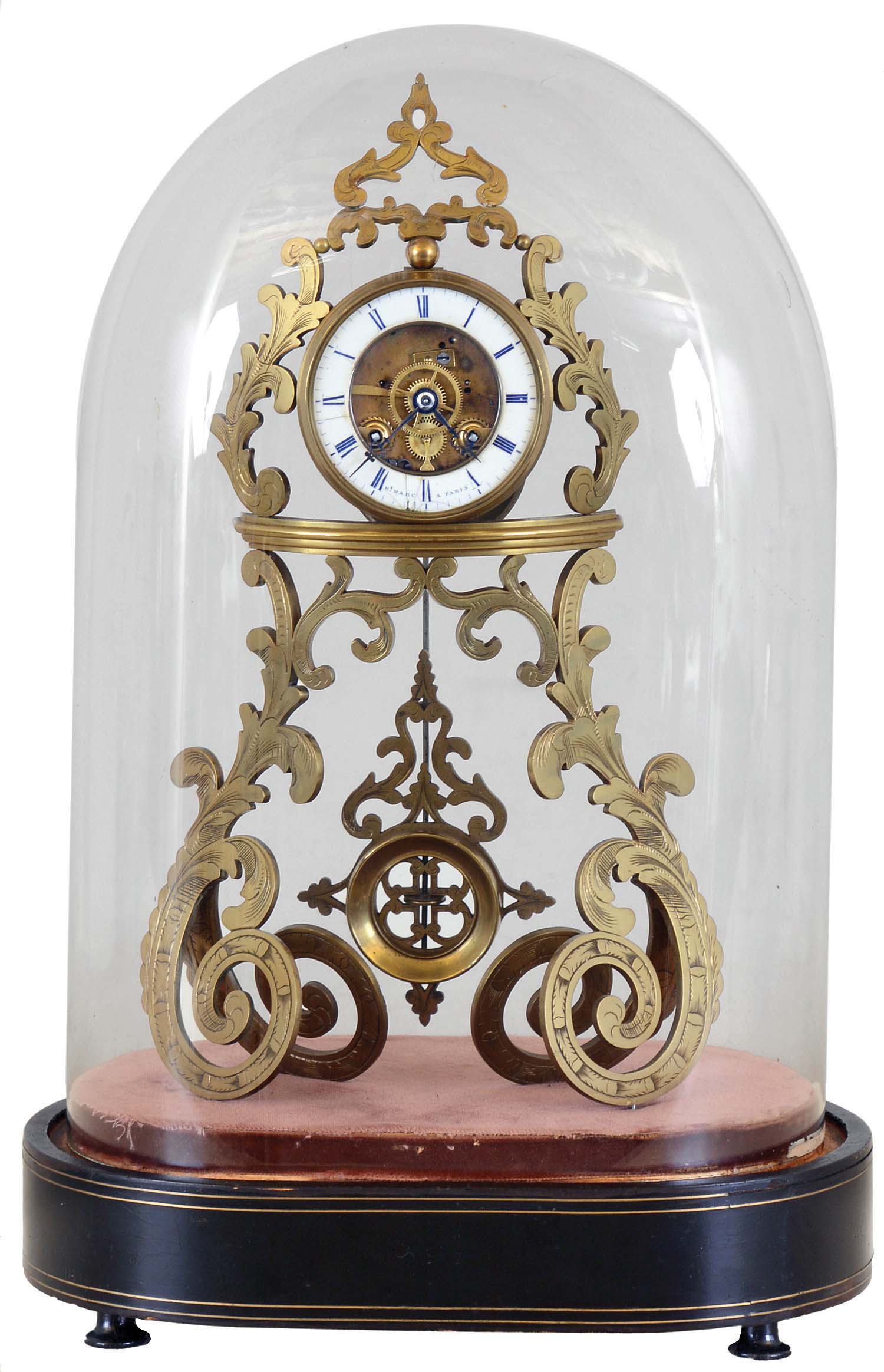 Hy. Marc, a Paris, table or mantel clock with skeletonized case and dial, pierced and engraved, scroll form brass case, pendulum similarly pierced and decorated, and also showing Gothic influence, signed Roman numeral white enamel dial, blued steel hands, 8 day, time and strike pendule de Paris movement, all mounted to an ebonized oval base with early velvet lining and brass line inlay, and covered with a glass shade, c1855 — Antique Clocks Price Guide