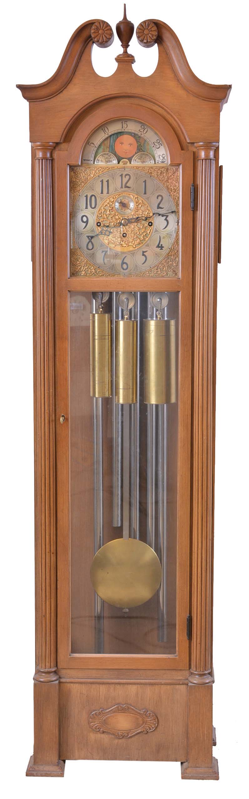 Herscede Hall Clock Co., Cincinnati, Ohio, "Patent No. 121" variant tall clock, 8 day, time, strike and Westminster chime on 5 tubular bells in a hard wood case with antique French finish, broken arch top and glass sides. The brass dial has silvered chapter ring, moon phase, raised numerals, cut brass spandrels and dial center and second's bit. — Antique Clocks Price Guide