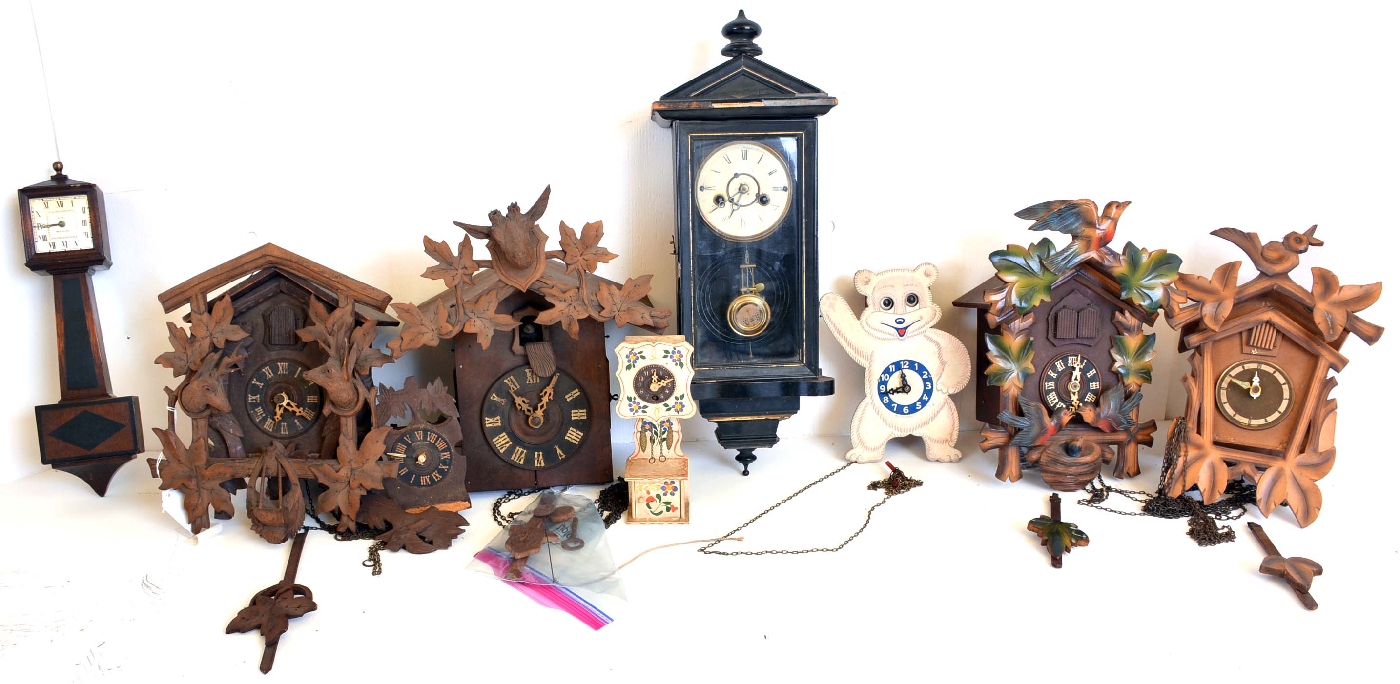 Clocks- 8 (Eight) German / Black Forest and novelty wall clocks: four cuckoos, a miniature Vienna spring driven, a miniature New Haven banjo, a miniature cuckoo and grandfather clock and a moving eye novelty wall clock — Antique Clocks Price Guide