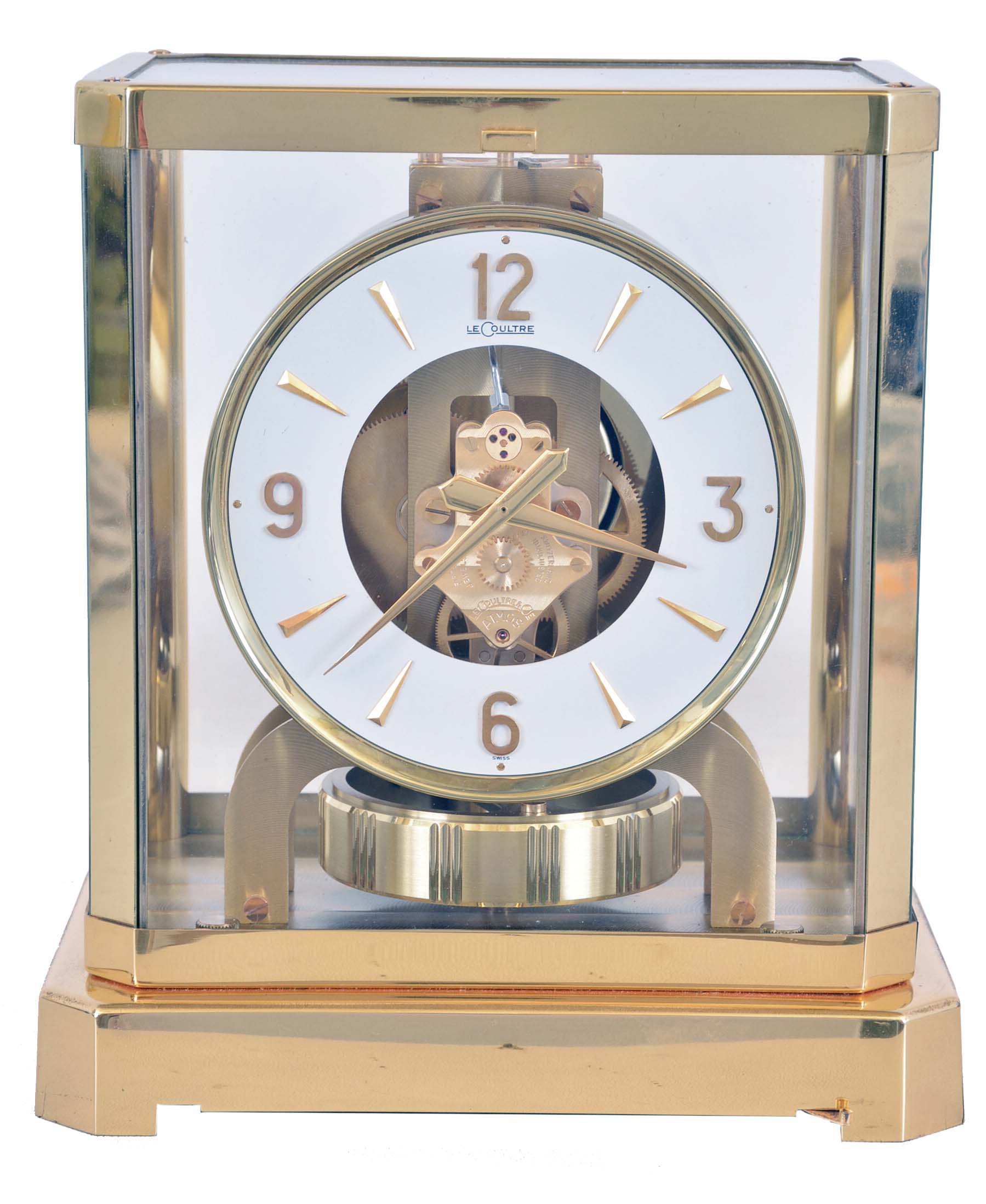 LeCoultre &amp; Cie, Switzerland, "Atmos" clock, 15 jewel gilt caliber 528 movement, gilt torsion pendulum, round white painted dial with applied gilt Arabic numerals and arrow markers, gilt hands, contained in a glazed rectangular case with removable front panel, serial #224079 — Antique Clocks Price Guide