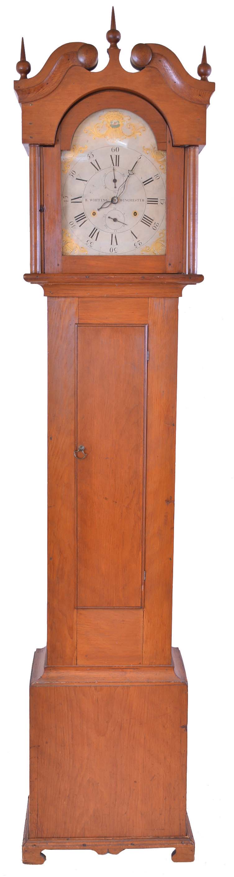 Riley Whiting, Winchester, Conn., tall clock, 30 hour, time and strike, weight driven wooden works movement in a pine case with broken arch crest and applied bracket base, painted wooden dial indicating seconds and calendar. — Antique Clocks Price Guide