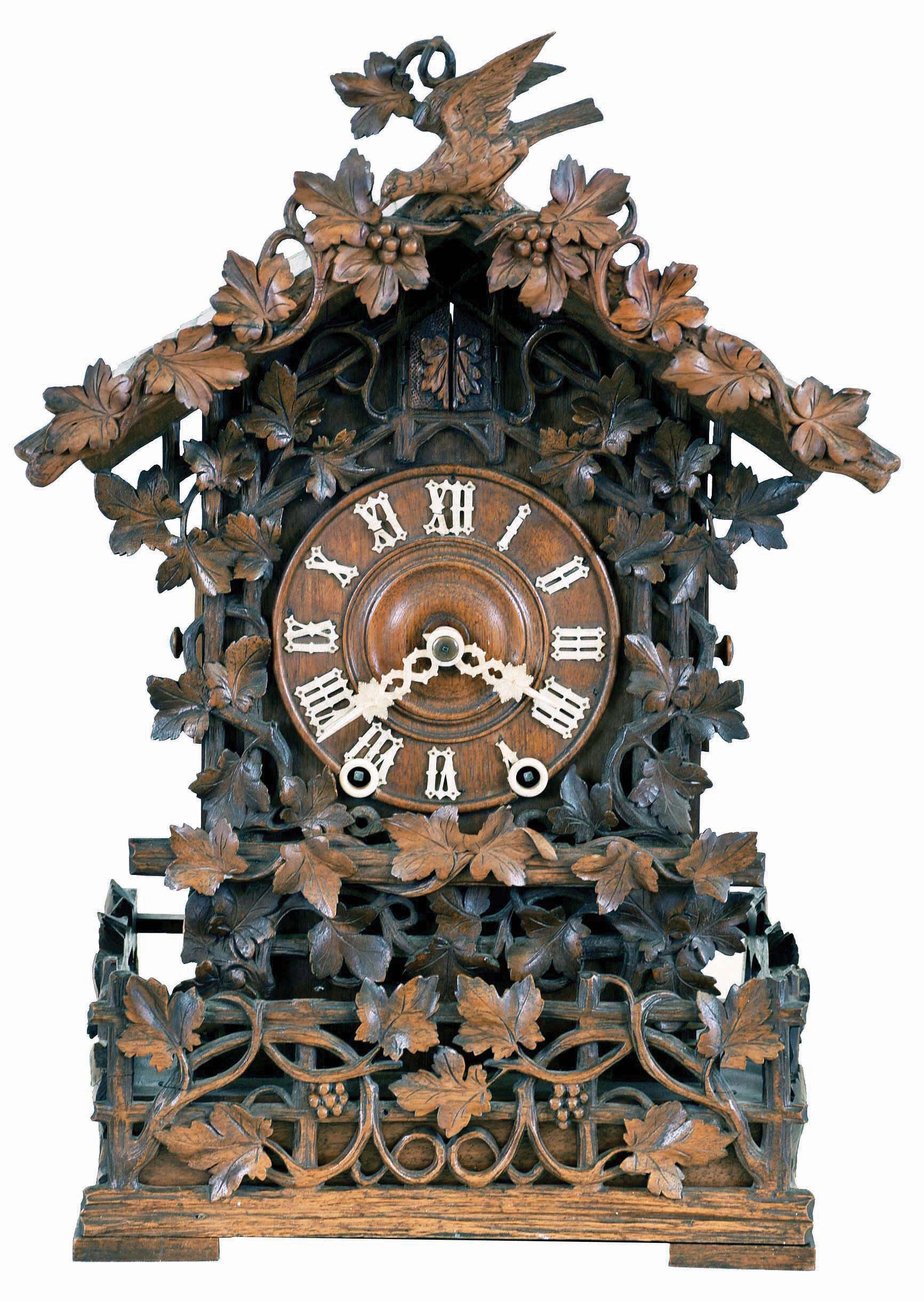 Johann Baptist Beha, Eisenbach, model 512 shelf cuckoo, nicely carved case with rustic railings covered in vines, roof with individually carved shakes and also trimmed with rustic ornament, vines, and a carved bird, Roman numeral wooden dial, pierced and carved bone hands, full body carved and painted cuckoo, 8 day, time and strike fusee movement with wooden plates, case back with the label of Camerer, Cuss &amp; Co. — Antique Clocks Price Guide