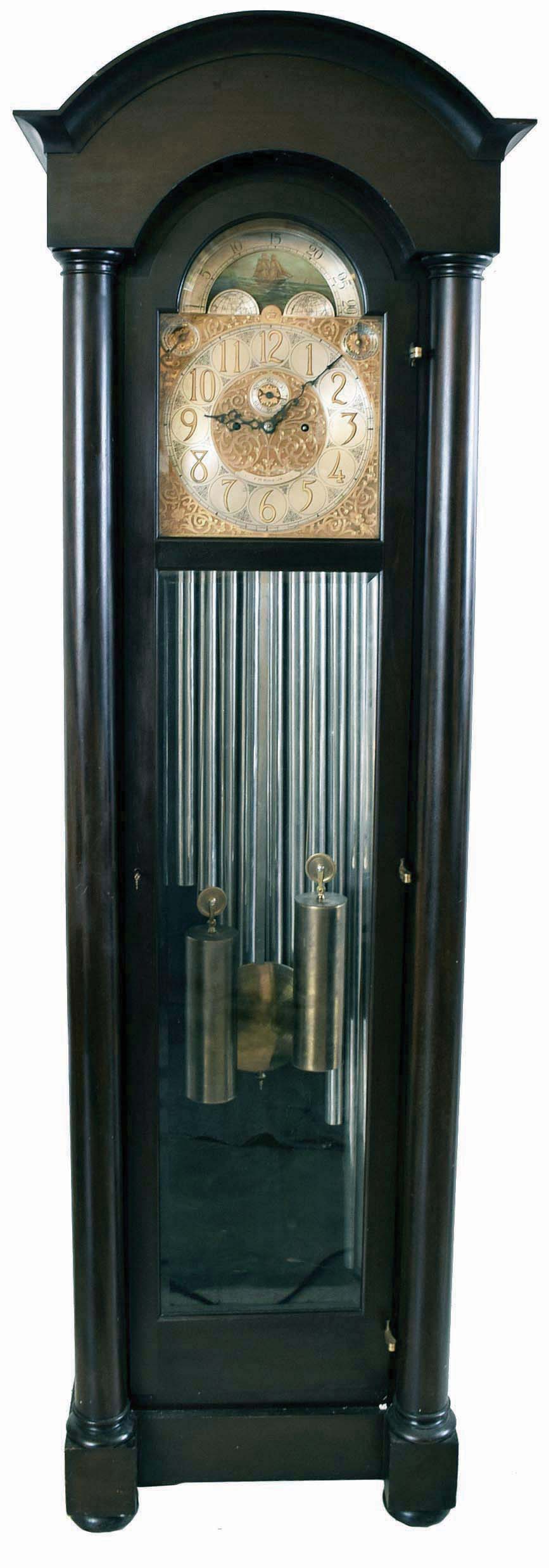 Herschede Hall Clock Co., Cincinnati, Ohio, "Pattern No. 86" hall clock, 8 day, time, strike and chime on 9 tubular bells, two brass weight driven movement in a mahogany case with full columns, beveled glass door and sides, arch top and resting on bun feet. The silvered brass dial has moon phase, spandrels, tune selector for Westminster or Whittington signed F.M. King JR, serial #3242 — Antique Clocks Price Guide