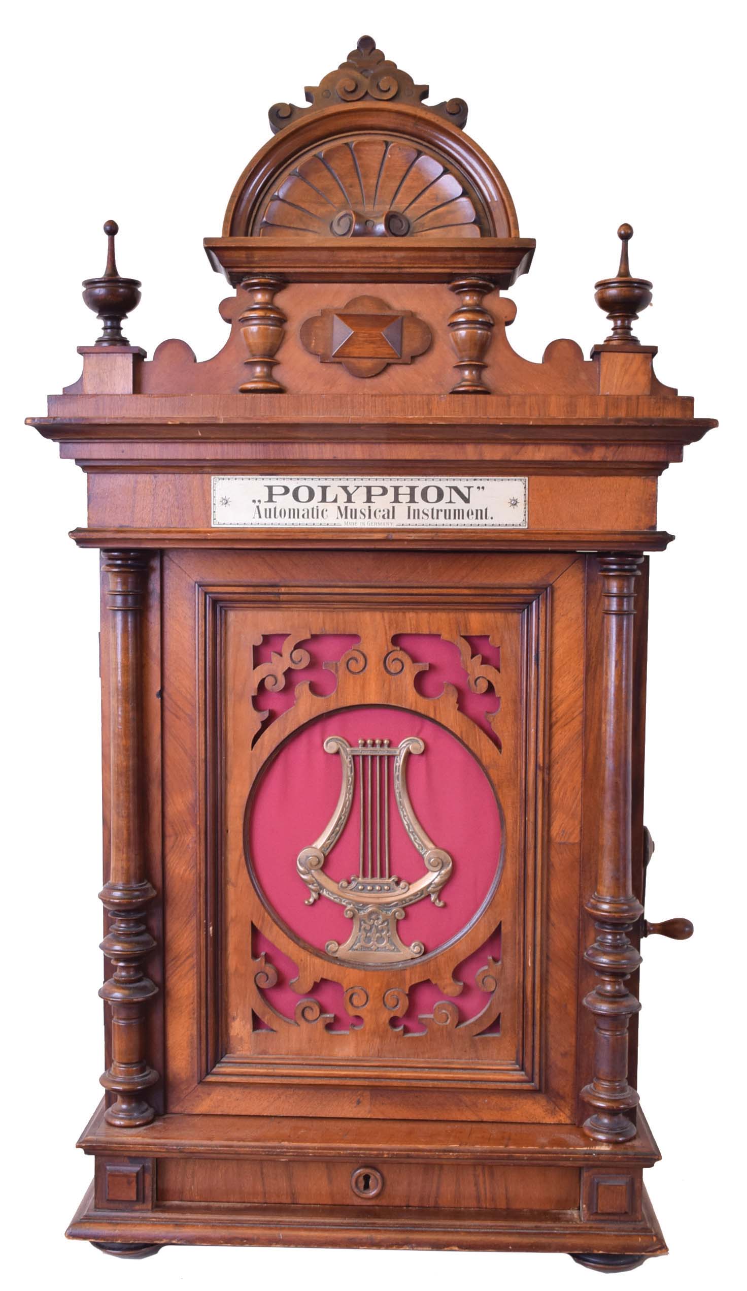 Polyphon Musicwerke, Leipzig, Germany, "Style No. 104 Upright" music box with double combs playing 15 1/2" discs on coin operated spring wound movement with lever for manual operation activated by turning a key on the side of the case to circumvent coin operated feature in a carved walnut cabinet with harp decorated front door, including 7 discs — Antique Clocks Price Guide