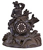 Germany, a large black forest figural mantel clock, the case with seated hunter scanning the horizon, (perhaps waiting for a bus), with carved stump, rocks, foliage, and kill at his feet, wooden dial with applied Roman numeral cartouches, blued steel Breguet style hands, 8 day time and strike pendule de Paris movement