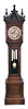E. Howard & Co., Boston, No. 77 hall clock with Westminster chimes, mahogany case, the molded base with inset panel, trunk door with fan carved corners and beveled glass, the interior lined with black flocked paper, and bonnet with carved grotesque mask, gryphons, and gothic style pinnacles, 14 inch, Arabic numeral silvered dial, blued steel English pattern hands, 8 day, three train movement with Graham deadbeat escapement, full Westminster chiming, stopwork on all trains, and counting the hours on a gong, brass weights, heavy brass pendulum with gilt cherry rod