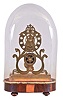 England, skeleton clock, the eight day fusee timepiece with nicely designed and executed scroll frames, the pattern similar to those used by Condliff for their great wheel clocks, Roman numeral brass dial with scalloped edge and oval piercing, brass hands and pendulum, mounted to a gilt plinth, and fixed to a velvet lined, rosewood veneered base with turned feet and dome