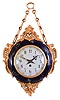 Wiemert, Paris, a two sided chatelaine clock, round, cobalt blue ceramic case with gilt and enamel foliage, and mounted with gilt naturalistic ornaments in the rococo style, gilt bezels with convex glasses, front and back with Arabic numeral white enamel dials, blued steel hands, 8 day timepiece movement with cylinder platform