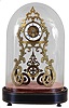 Hy. Marc, a Paris, table or mantel clock with skeletonized case and dial, pierced and engraved, scroll form brass case, pendulum similarly pierced and decorated, and also showing Gothic influence, signed Roman numeral white enamel dial, blued steel hands, 8 day, time and strike pendule de Paris movement, all mounted to an ebonized oval base with early velvet lining and brass line inlay, and covered with a glass shade, c1855