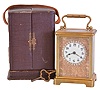 France, carriage clock, brass Corniche case with beveled glasses, Arabic numeral white enamel dial with engraved mask and brilliant set surround, 8 day timepiece movement with lever platform, and leather covered travel case