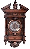 France, a large architectural wall clock, walnut case with nicely carved and turned ornament, pitched pediment, and base with scrolls, bellflowers, and central cartouche, turned wooden bezel with convex glass, dial with Roman numeral enamel cartouches, 8 day time and strike movement