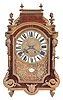 France, a 19th century Religieuse style mantel clock, the case with tortoise shell veneers, brass moldings and cast foliate ornament, corners mounted with half Atlantes figures, and the top with gadrooned flame finials, velvet lined dial with repousse style brass dial set with Roman numeral enamel cartouches, and with foliate mask below, with cartouche signed "Martinot a Paris", 8 day, time and strike movement with square plates