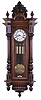 Austria, a large grand sonnerie hanging regulator, walnut case with carved and turned ornament, large base and cornice moldings, and foliate carved crest, Roman numeral two piece white enamel dial, 8 day, weight driven, three train quarter striking movement, brass pendulum with wooden rod, and three brass weights