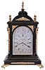 John Walker Ltd., London, large bracket clock, ebonized case with caryatid corners, and set with cast, gilt mounts and ornamental scroll feet, the sides with cast, pierced frets with Helios mask, and foliate ornamented carrying handles, case top with five finials; engraved, silvered sheet brass Roman numeral dial, the arch with controls for regulation and chiming, blued steel hands, large three train fusee movement, with Cambridge Chime or Chime on Eight Bells at the quarters, and counting the hours on a large gong, dial and movement signed