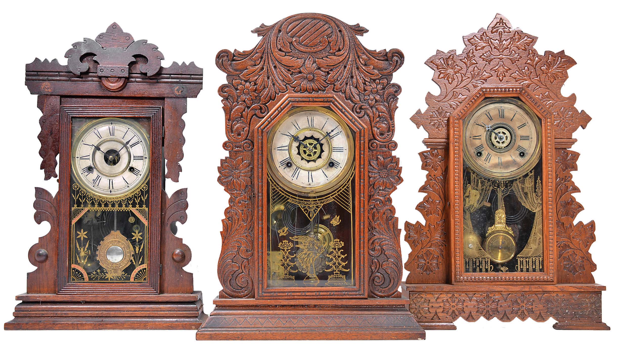 Clocks- 6 (Six) American Gingerbread in oak case, time and strike: (1) New Haven "Mayor" with alarm with patented removable top; (2) Gilbert with alarm and pendulum with regulator; (3) Waterbury with alarm with floral motif; (4) E. Ingraham "Dewey" model with eagle pendulum (partial) ; (5) Gilbert "Navy No. 28" with alarm; (6) Sessions in dark oak case — Antique Clocks Price Guide