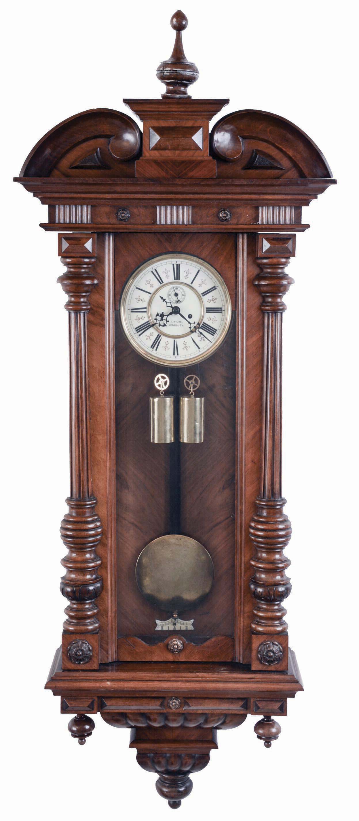 Germany, a large 2-weight "Vienna Regulator", walnut case with turned and carved ornament, turned finial and drops, two piece Roman numeral enamel dial signed "J. Wilde, Monmouth, blued steel hands, 8 day time and strike, weight driven movement, brass pendulum with wooden rod, brass weights — Antique Clocks Price Guide