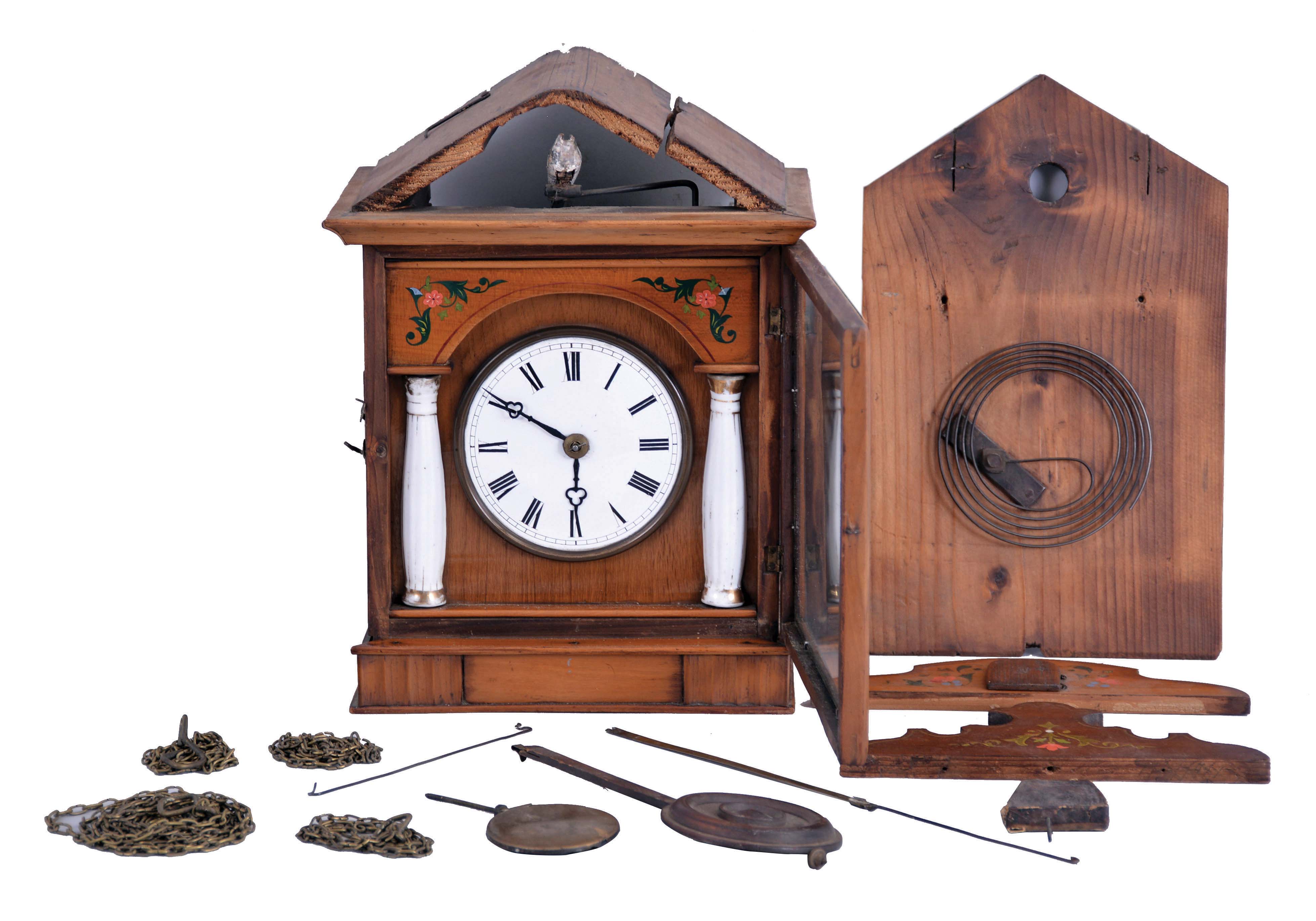 Germany, early Biedermeier cuckoo clock, 30 hour, weight driven movement in a wood case with stenciled floral design, fluted porcelain columns with gold accents and a white porcelain dial. Likely by Theodor Ketterer of Furtwangen, c1860. — Antique Clocks Price Guide