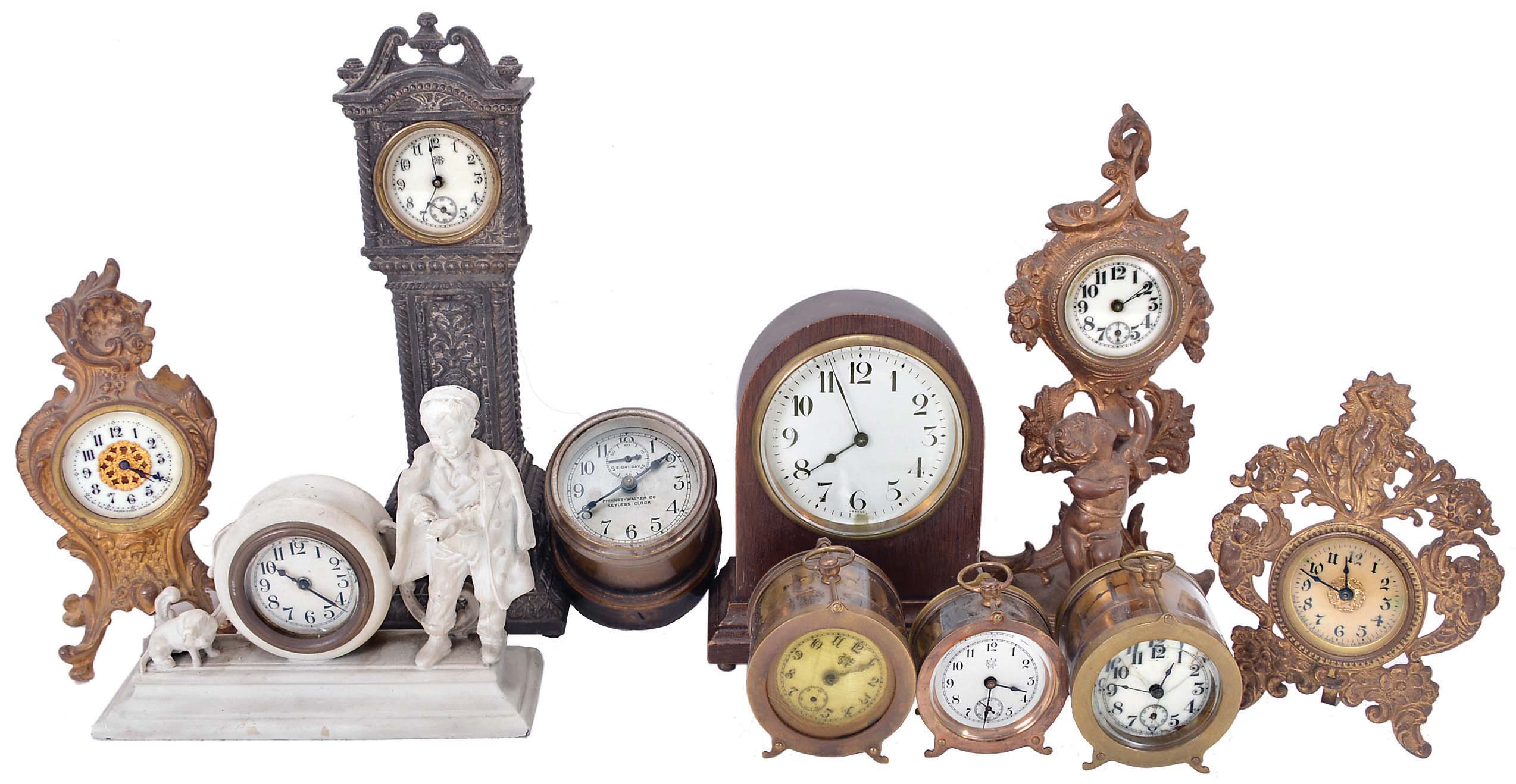 Clocks- 10 (Ten) novelty clocks including 3 (Three) Waterbury round desk clocks with glass sides; wood case French clock with time only balance wheel movement; miniature cast tall clock signed by Jennings Brothers on the dial; small figural clock with a dog and boy; keyless car clock signed by Phinney-Walker Co. — Antique Clocks Price Guide