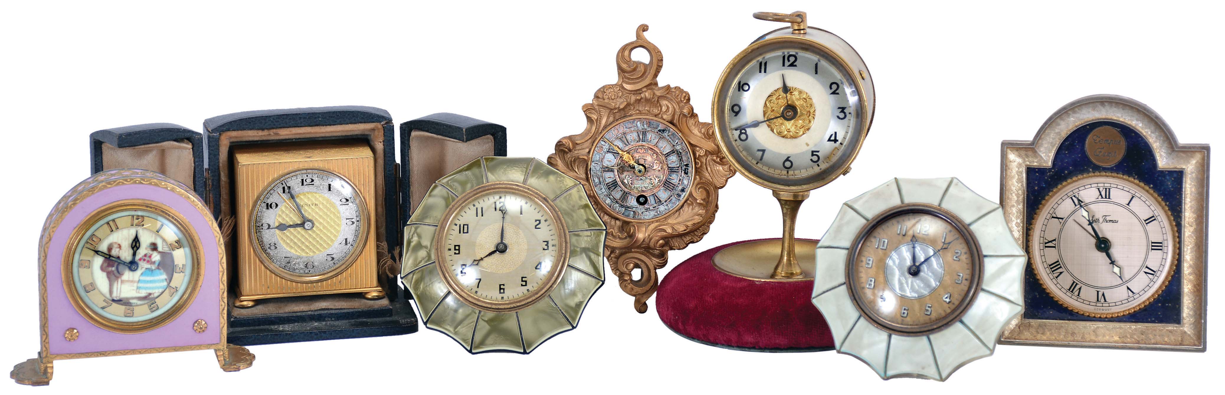 Clocks- 7 (Seven): including two "Lux" parasol novelties, a German alarm with lavender enamel and decorated dial, a miniature cartel style, a Zenith travel alarm with case, a British United novelty with velvet lined base, and a Seth Thomas — Antique Clocks Price Guide