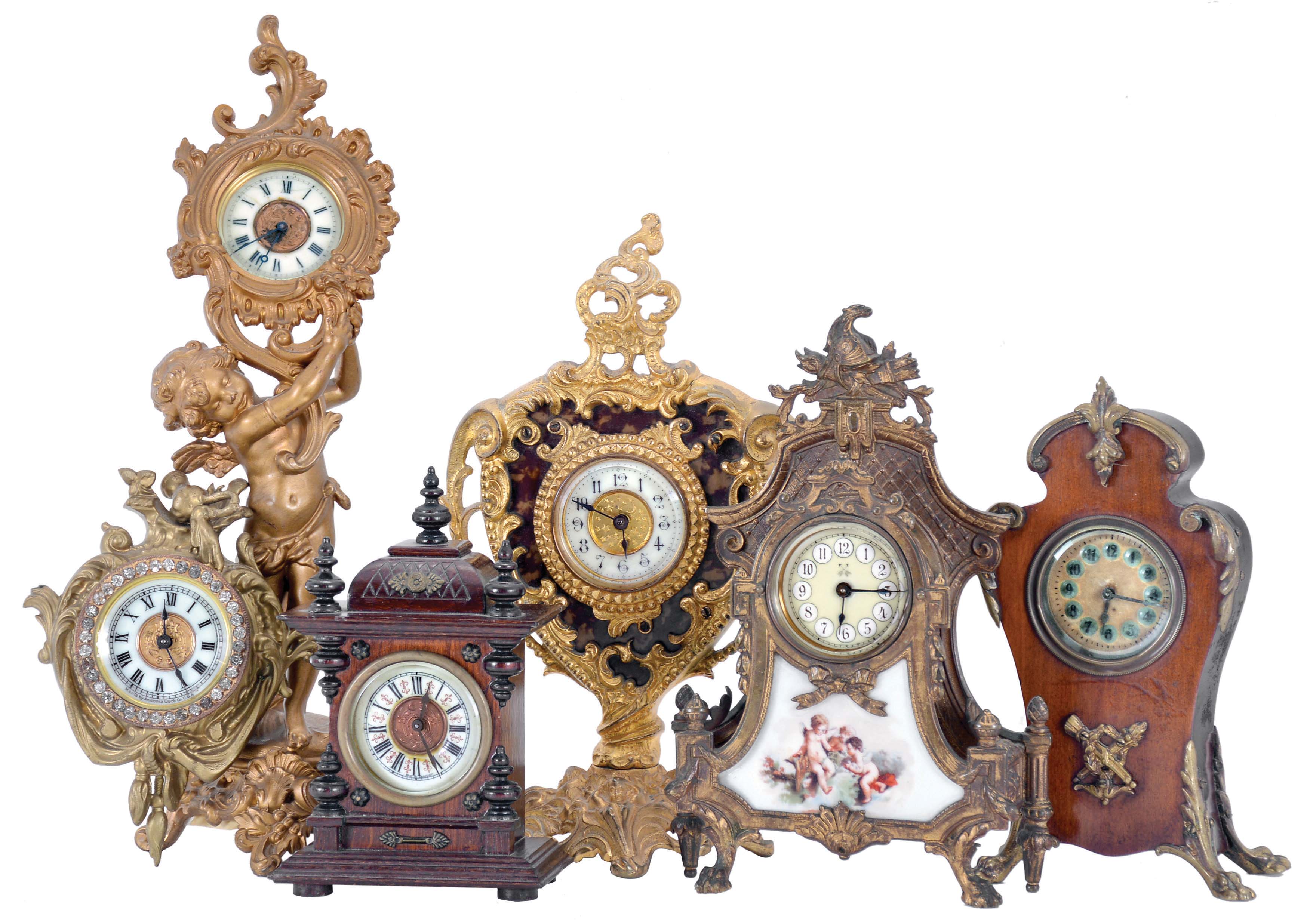 Clocks- 6 (Six): including an Ansonia figural with putto, an Ansonia cartel style, a Hamburg - American with gilt brass case set with porcelain panel featuring putti, a British United with gilt brass case, and two wooden miniatures — Antique Clocks Price Guide