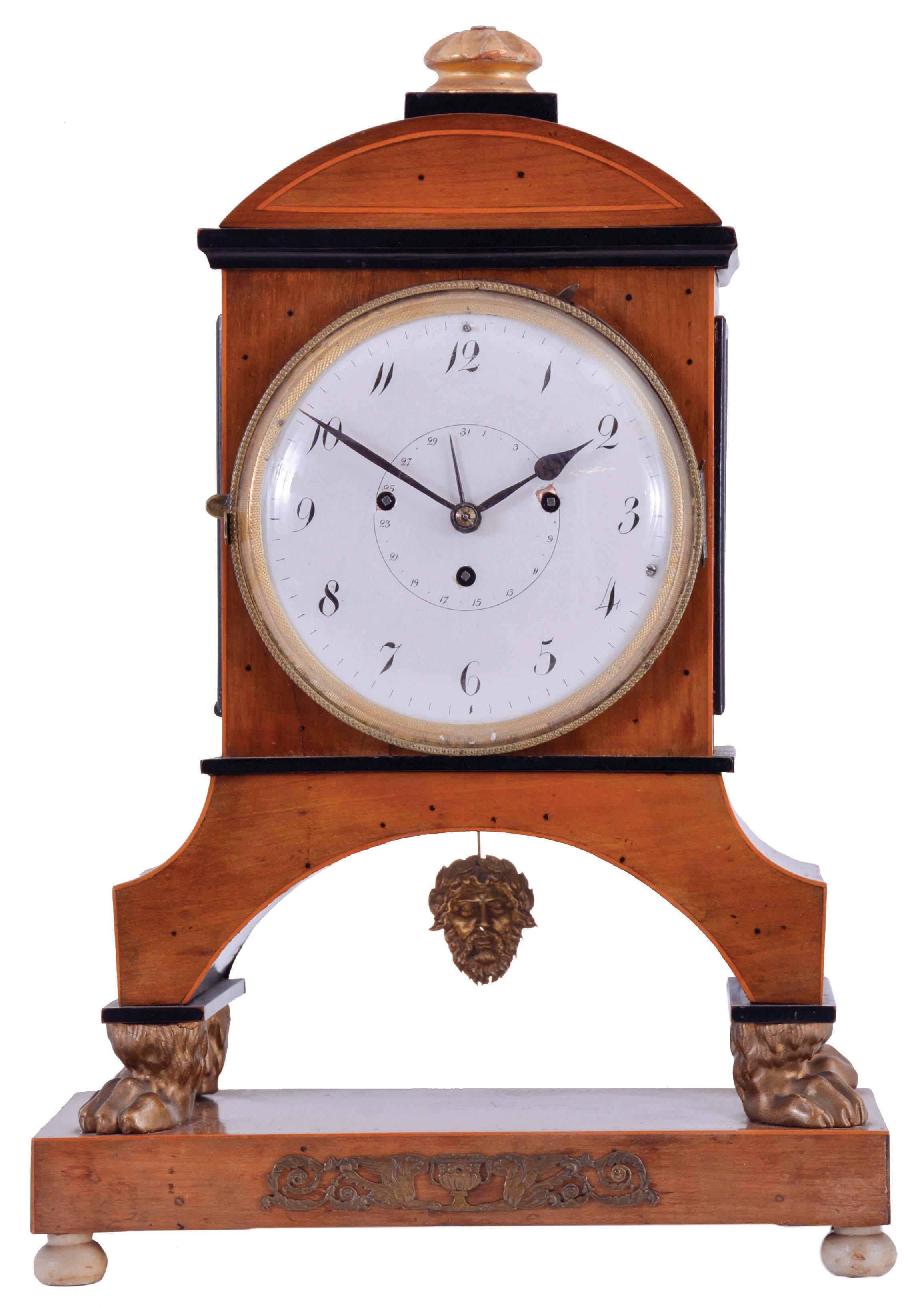 Vienna, Austria, Biedermeier mantel clock with grand sonnerie striking, fruitwood veneer case with ebonized trim and moldings, contrasting line inlay and brass mounts, resting on gilt paw feet, and supported on an oblong base with turned feet, Arabic numeral white enamel dial with date display, 60 hour, three train movement with silk thread suspension and mask pendulum — Antique Clocks Price Guide